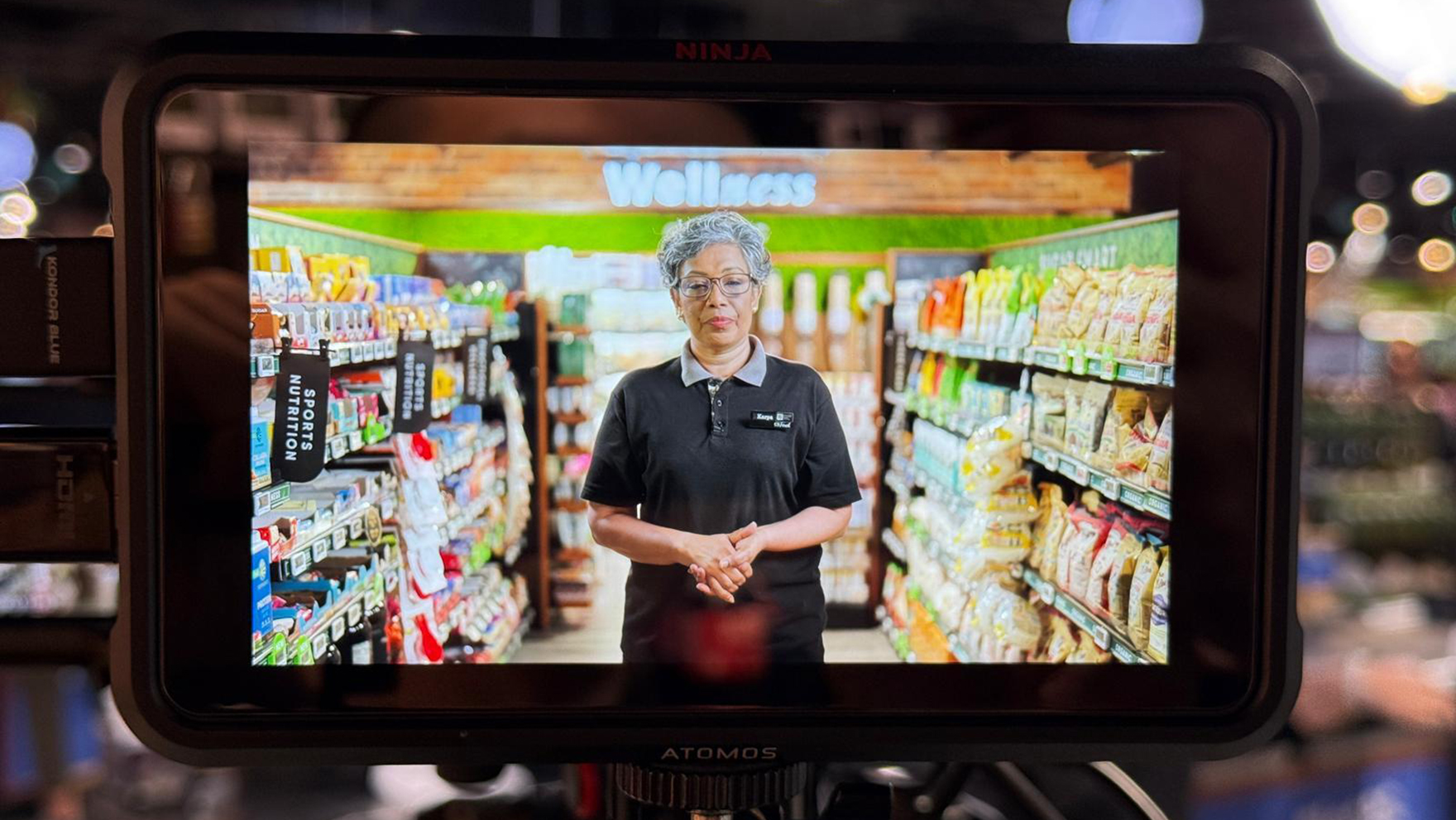 Tablet playing a video of a DFI colleague in a supermarket aisle